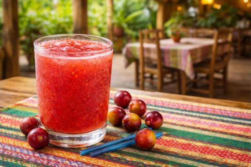 Refresco de camu camu servido en vaso con hielo y rodajas